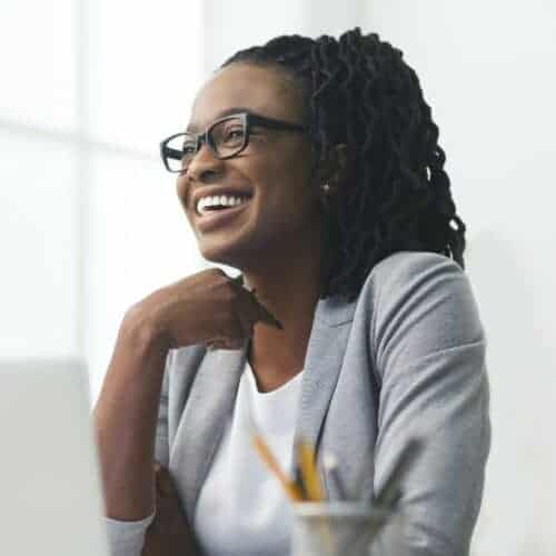 african american businesswoman laughing sitting against window in office e1631573683612 Copy